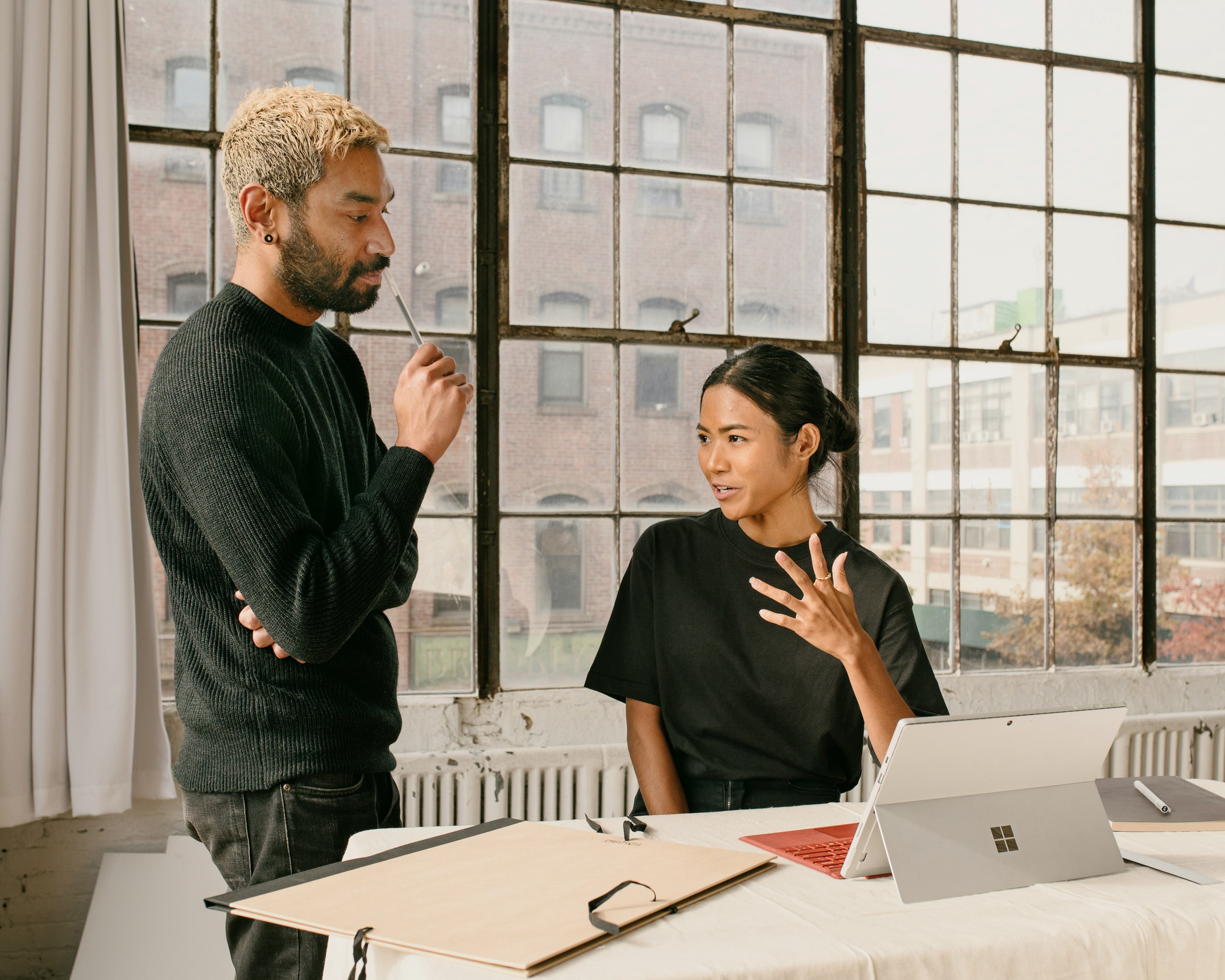 Two co-workers having a discussion in front of a computer